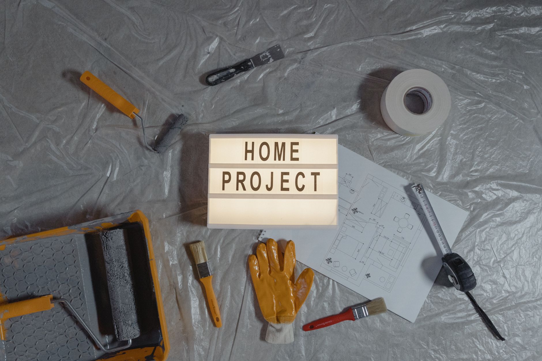 Flat lay of home improvement setup with tools, gloves, and floor plan for DIY projects. — 5 Most In-Demand General Contractor