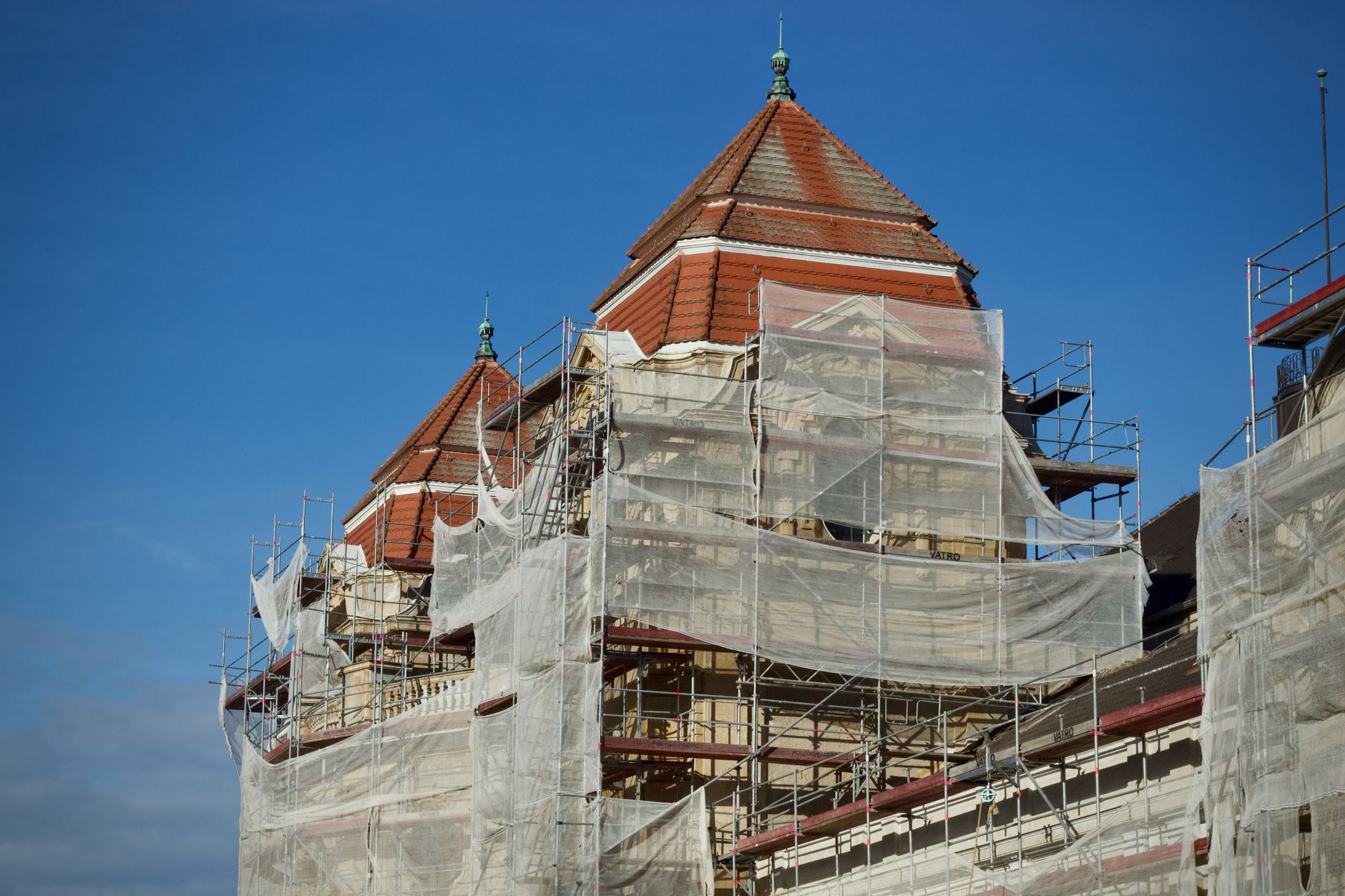 A historic building under restoration, covered in scaffolding and protective nets. — Expert Corporate Travel Management and t